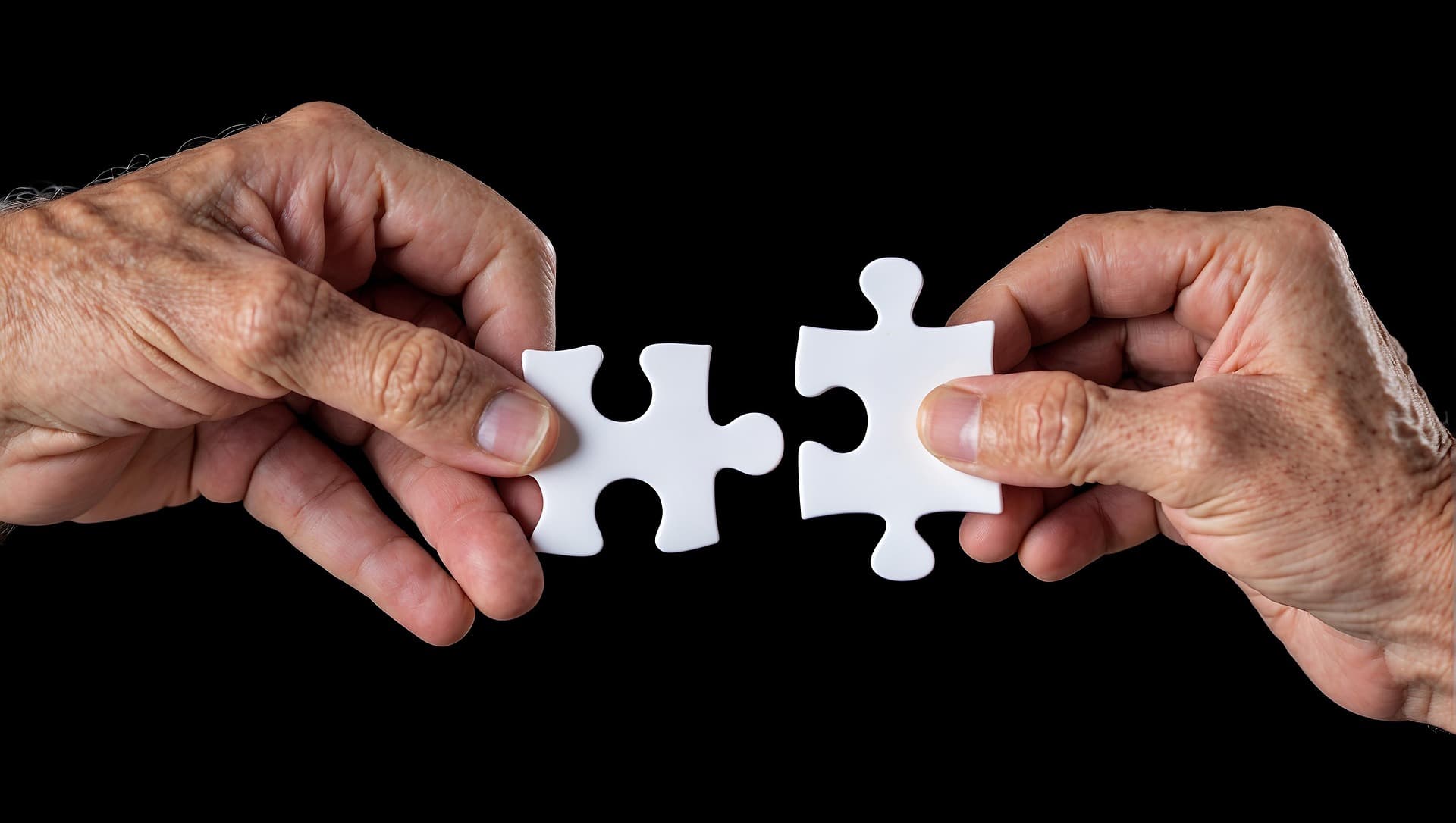 Dos manos sosteniendo piezas de rompecabezas